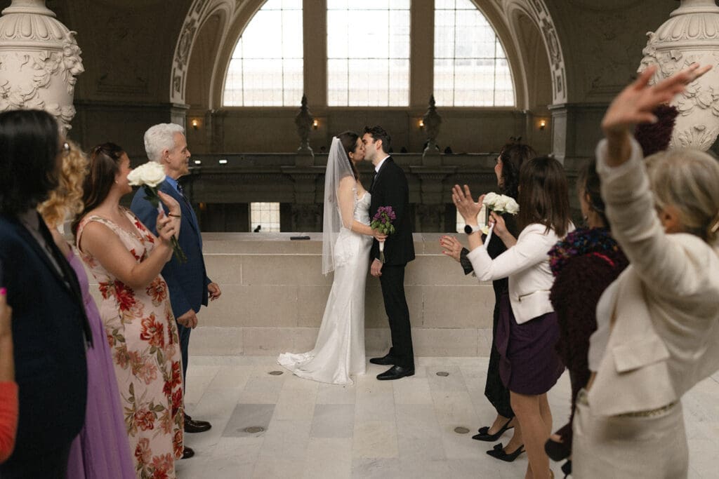 Bride and groom first kiss during San Francisco City Hall wedding ceremony