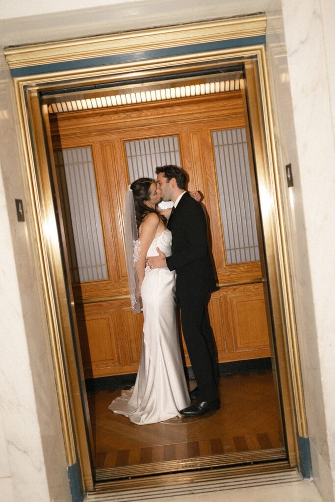 Bride and groom kissing in elevator at San Francisco City Hall