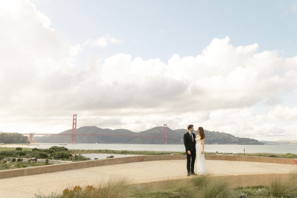 Bride and groom portrait at Presidio Tunnel Tops with Golden Gate Bridge in the background