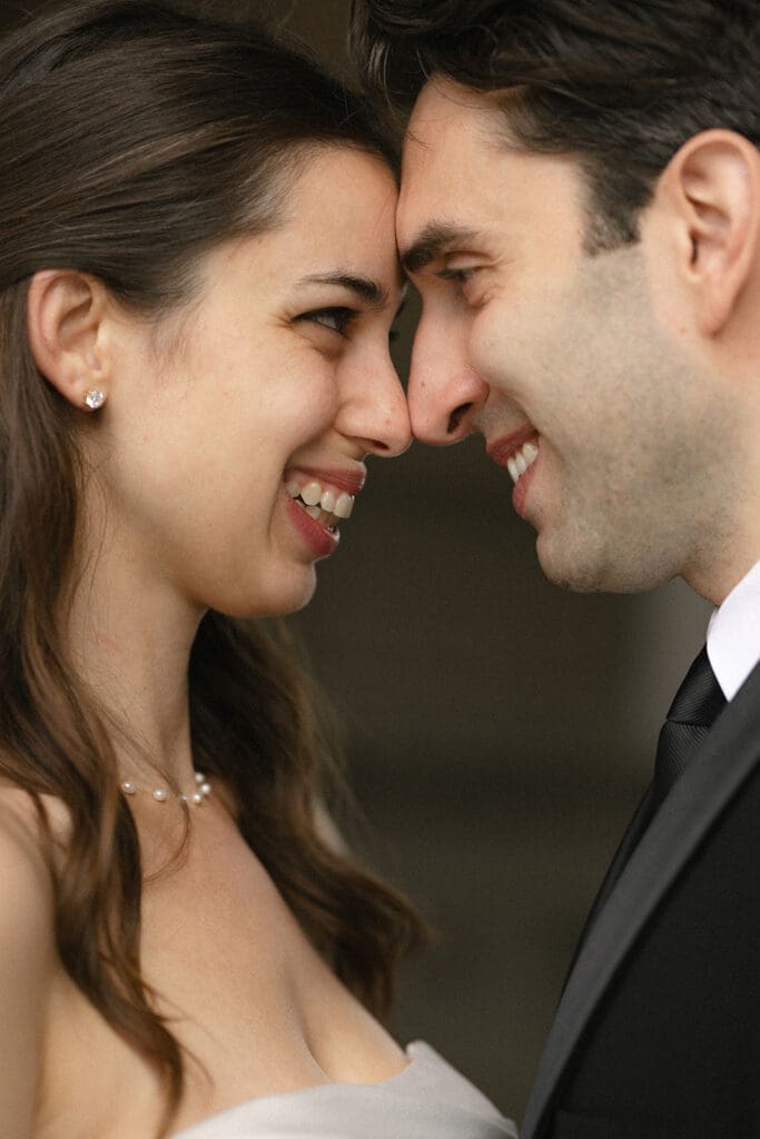 Close up of bride and groom touching foreheads and laughing at San Francisco City Hall