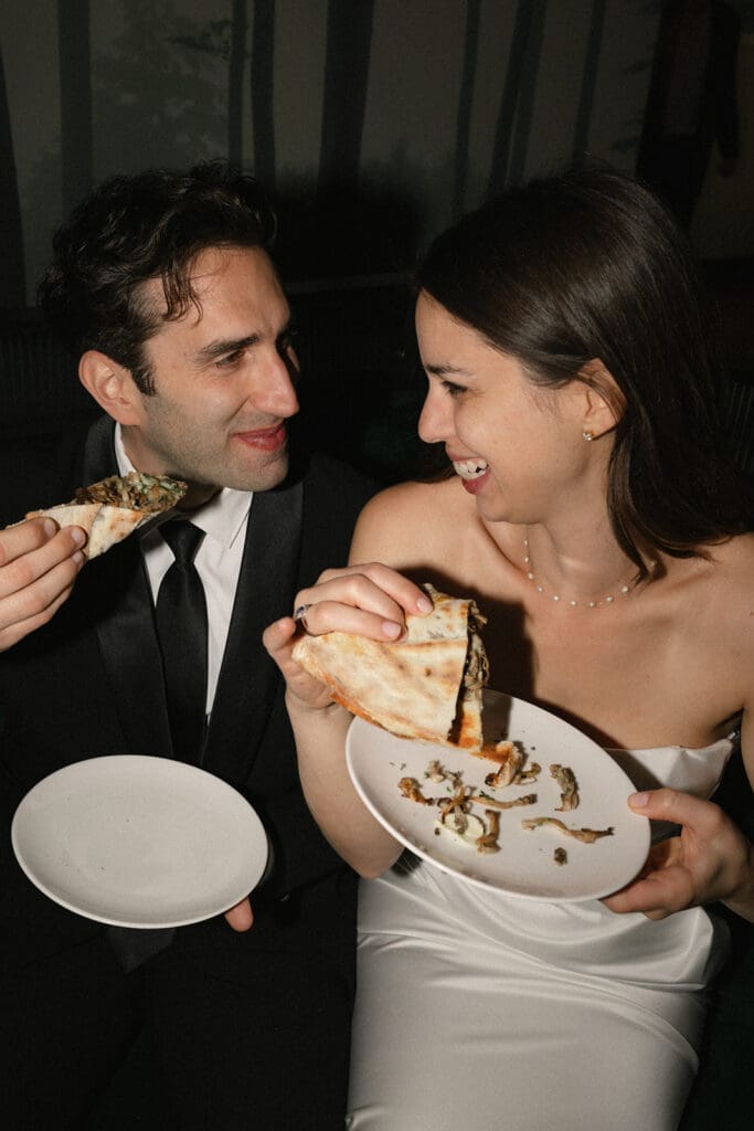 Bride and groom share a slice of pizza 