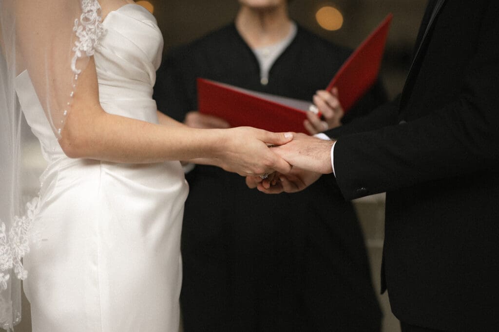 Bride and groom exchanging rings during San Francisco City Hall wedding ceremony