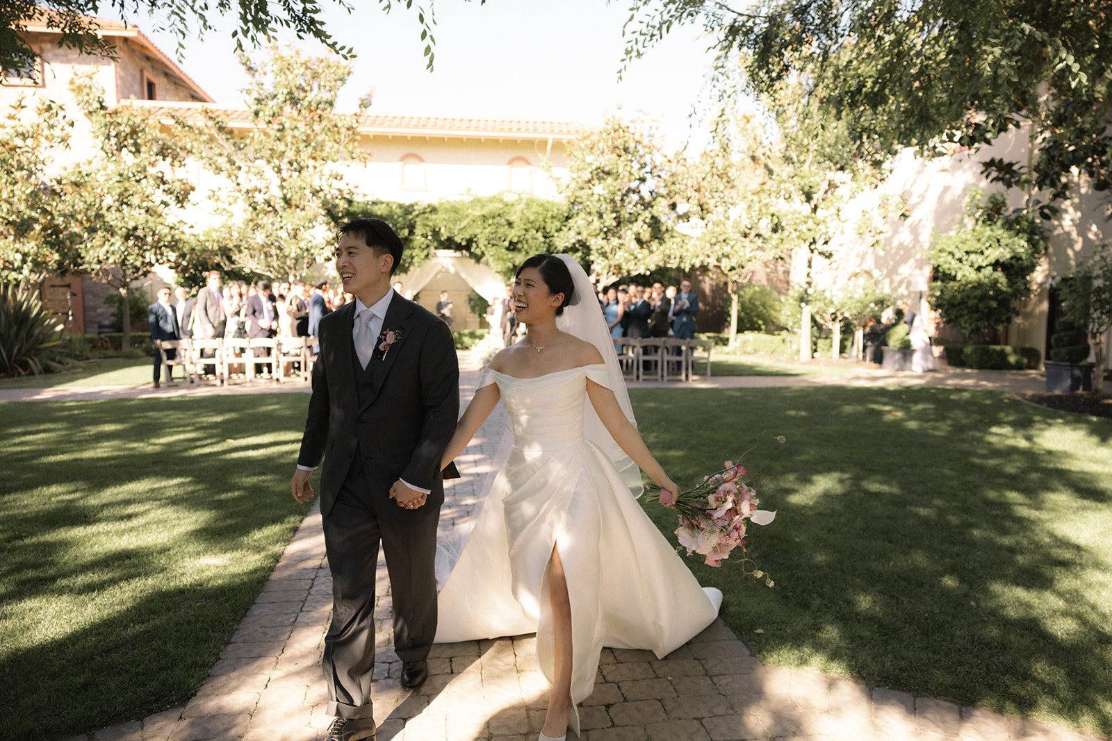Bride and groom walking hand in hand after their ceremony at casa real at ruby hill winery, captured by a bay area wedding photographer.
