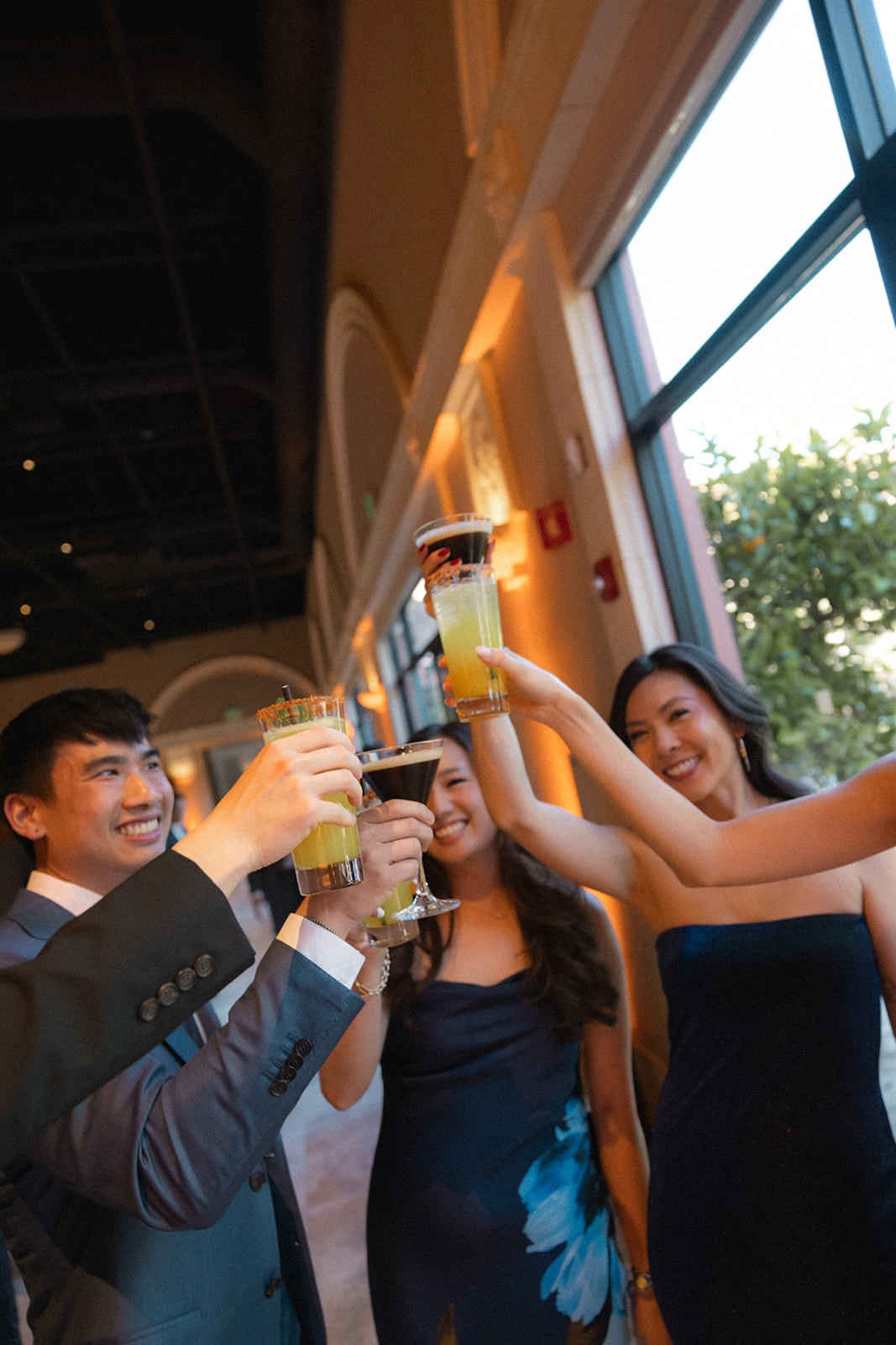 Wedding guests raise colorful cocktails for a celebratory toast during the reception at casa real at ruby hill winery, photographed by a bay area wedding photographer.