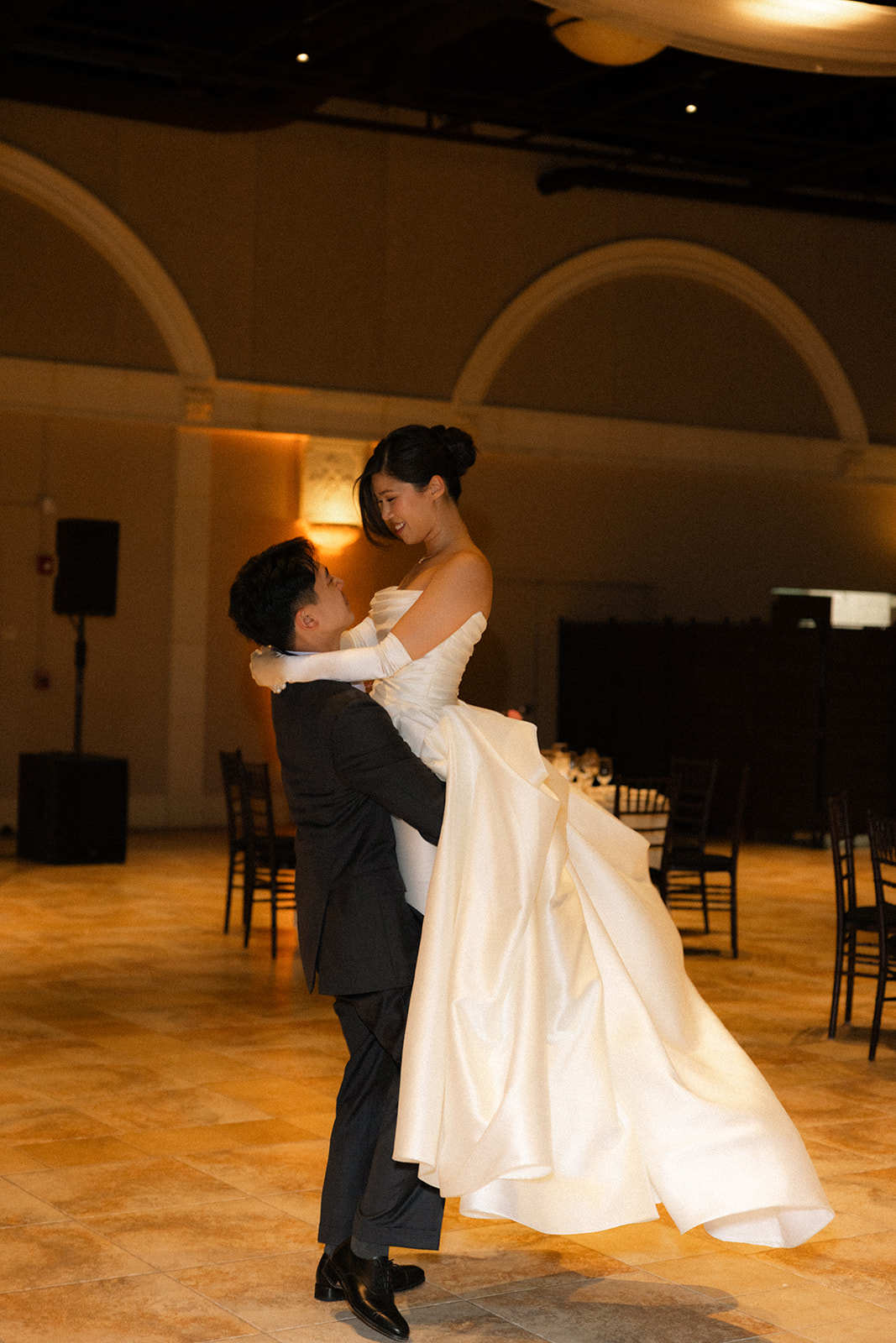 Groom lifts the bride during their first dance beneath soft reception lighting at casa real at ruby hill winery, showcasing romantic casa real at ruby hill winery photos.