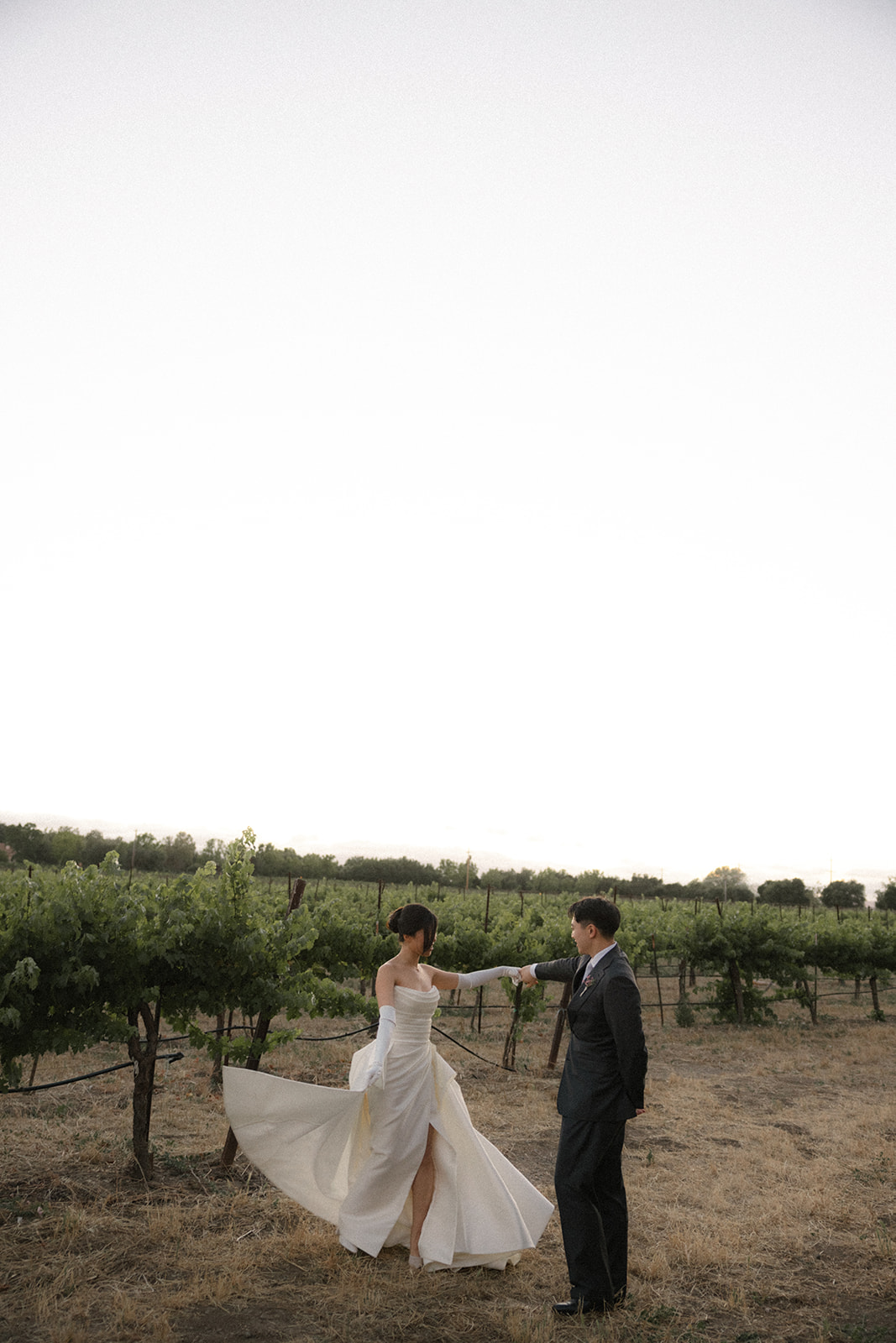 Bride twirling as the groom holds her hand in the vineyard at casa real at ruby hill winery, highlighting one of the most scenic bay area wedding venues.