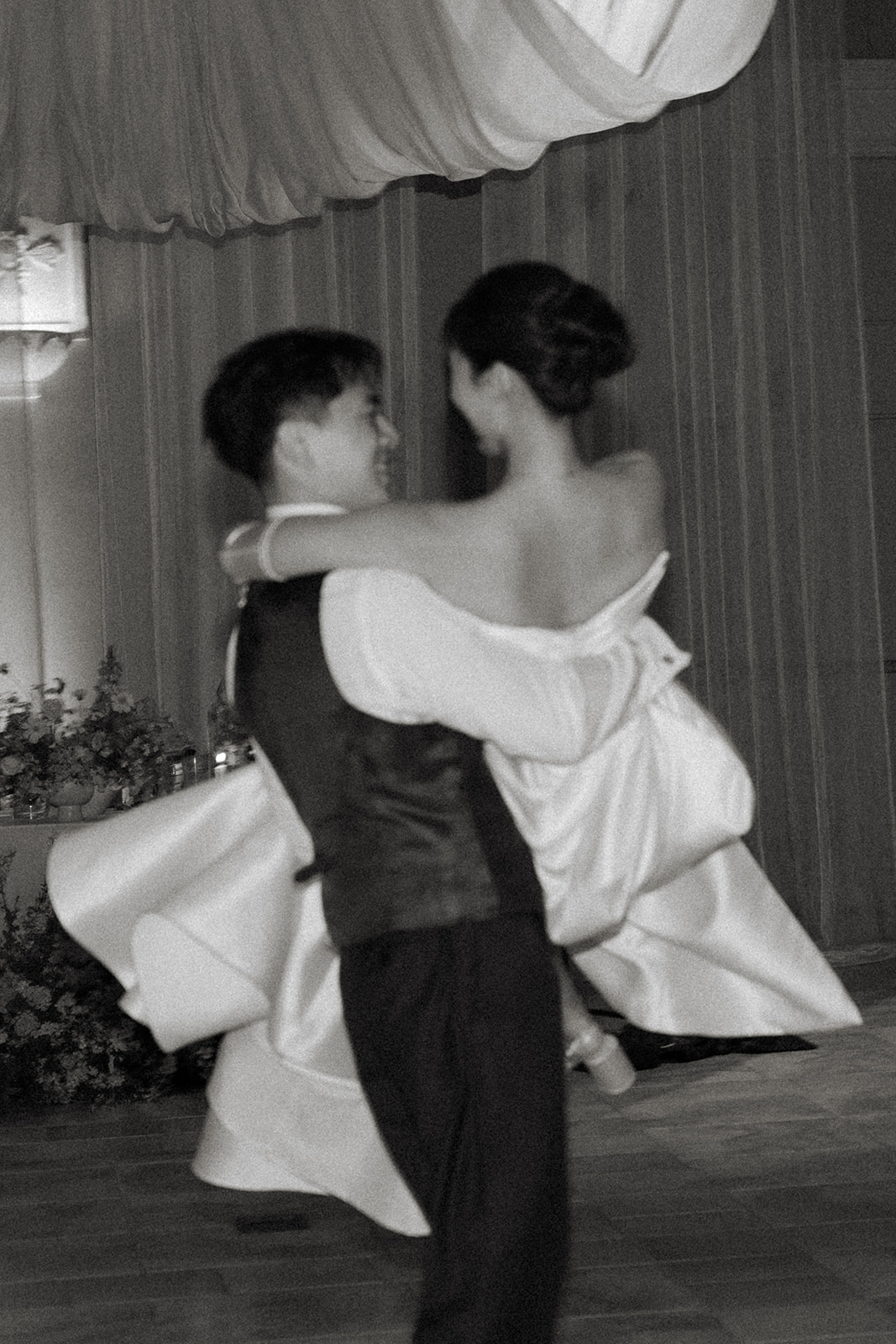 Groom twirls the bride across the dance floor during their reception under flowing drapery at casa real at ruby hill winery, photographed by a bay area wedding photographer.