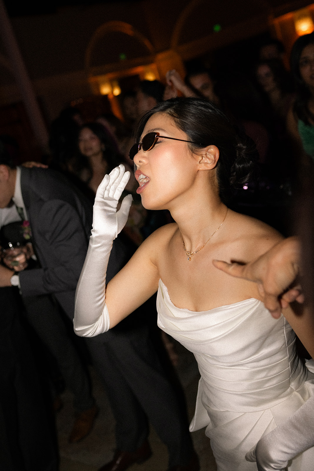 Bride wearing sunglasses dances with guests during the lively wedding reception at casa real at ruby hill winery, featured in casa real at ruby hill winery photos.