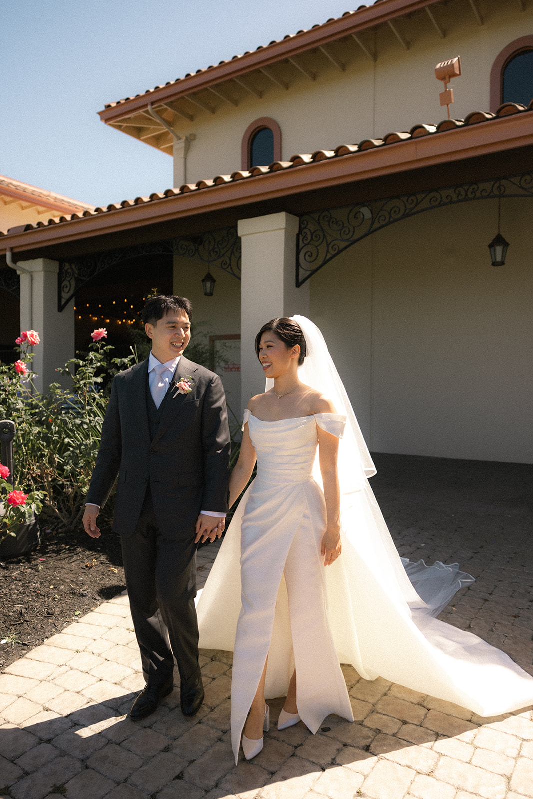Newlyweds walking hand in hand outside casa real at ruby hill winery, photographed by a bay area wedding photographer.