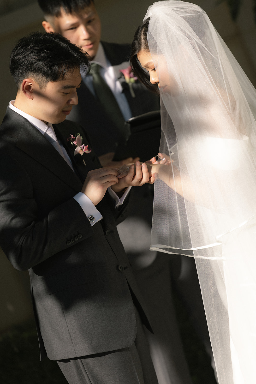 Groom placing a wedding ring on the bride’s finger during the ceremony at casa real at ruby hill winery, photographed by a bay area wedding photographer.