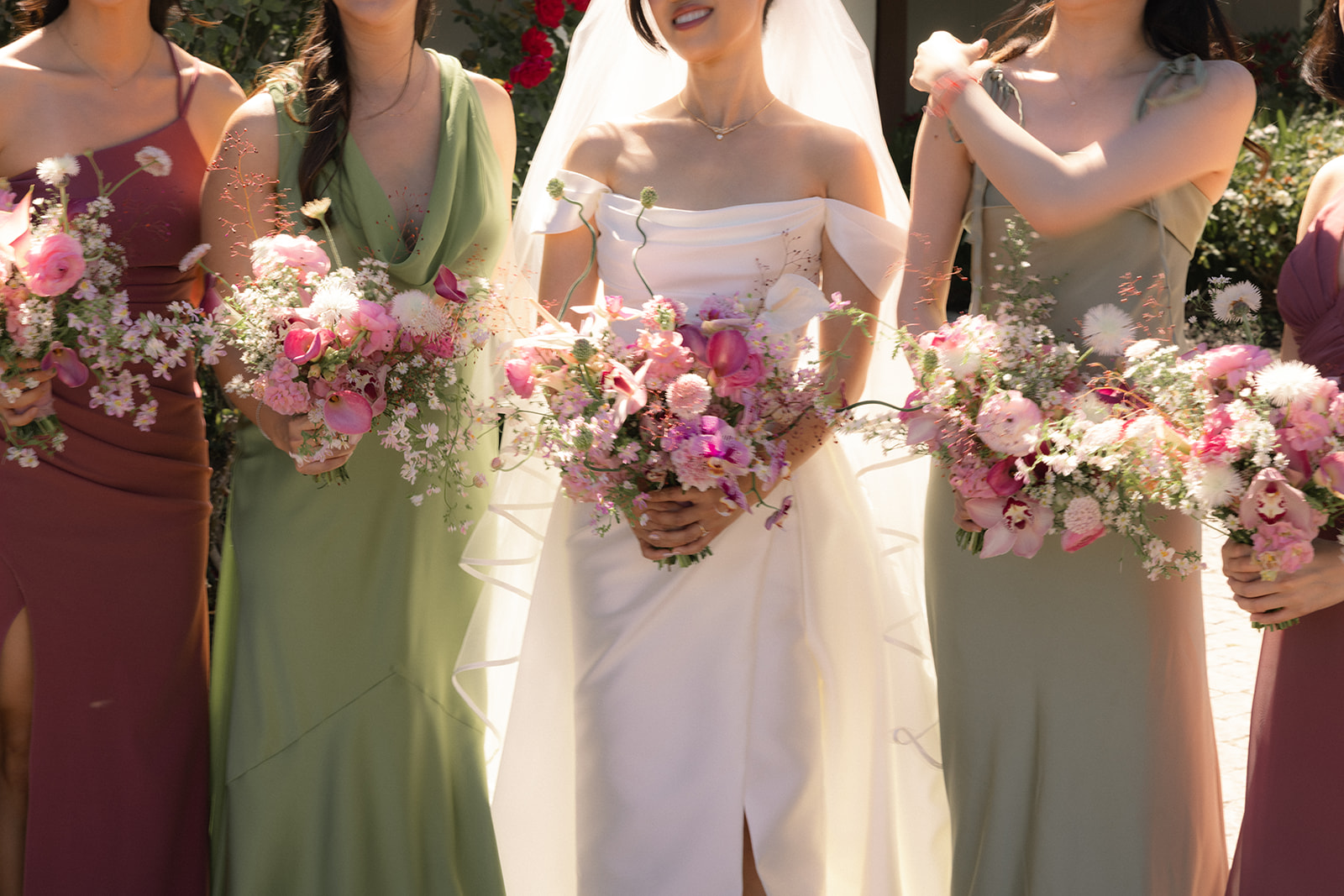 Bride and bridesmaids holding lush pink floral bouquets during portraits at casa real at ruby hill winery, photographed by a bay area wedding photographer.