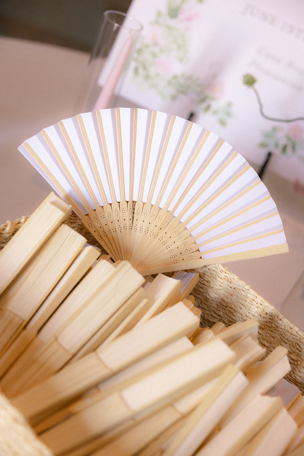 White folding fans displayed for guests during an outdoor ceremony at casa real at ruby hill winery, one of the most elegant bay area wedding venues.