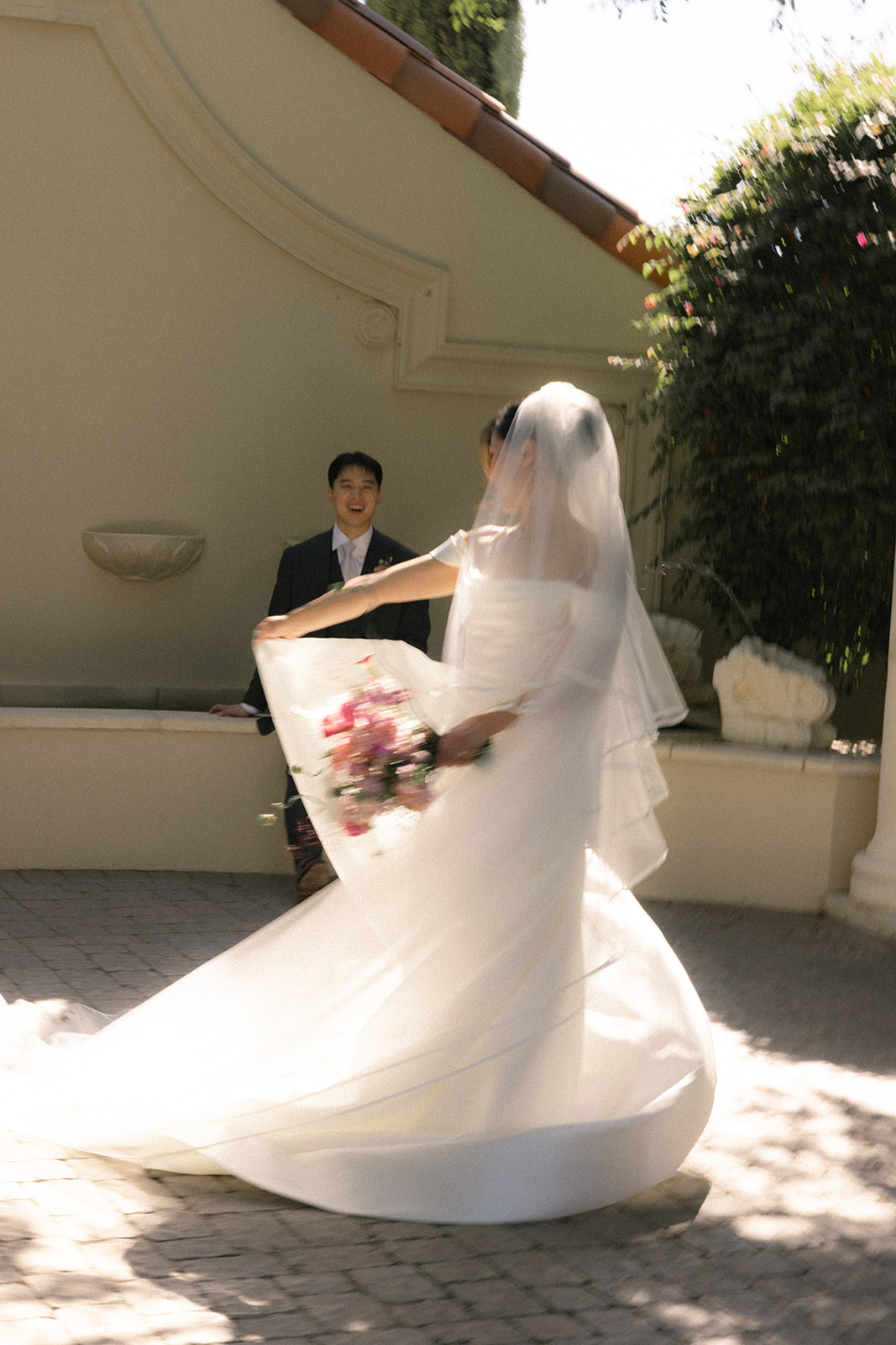 Bride twirling with her bouquet while the groom watches during wedding portraits at casa real at ruby hill winery, featured in casa real at ruby hill winery photos.