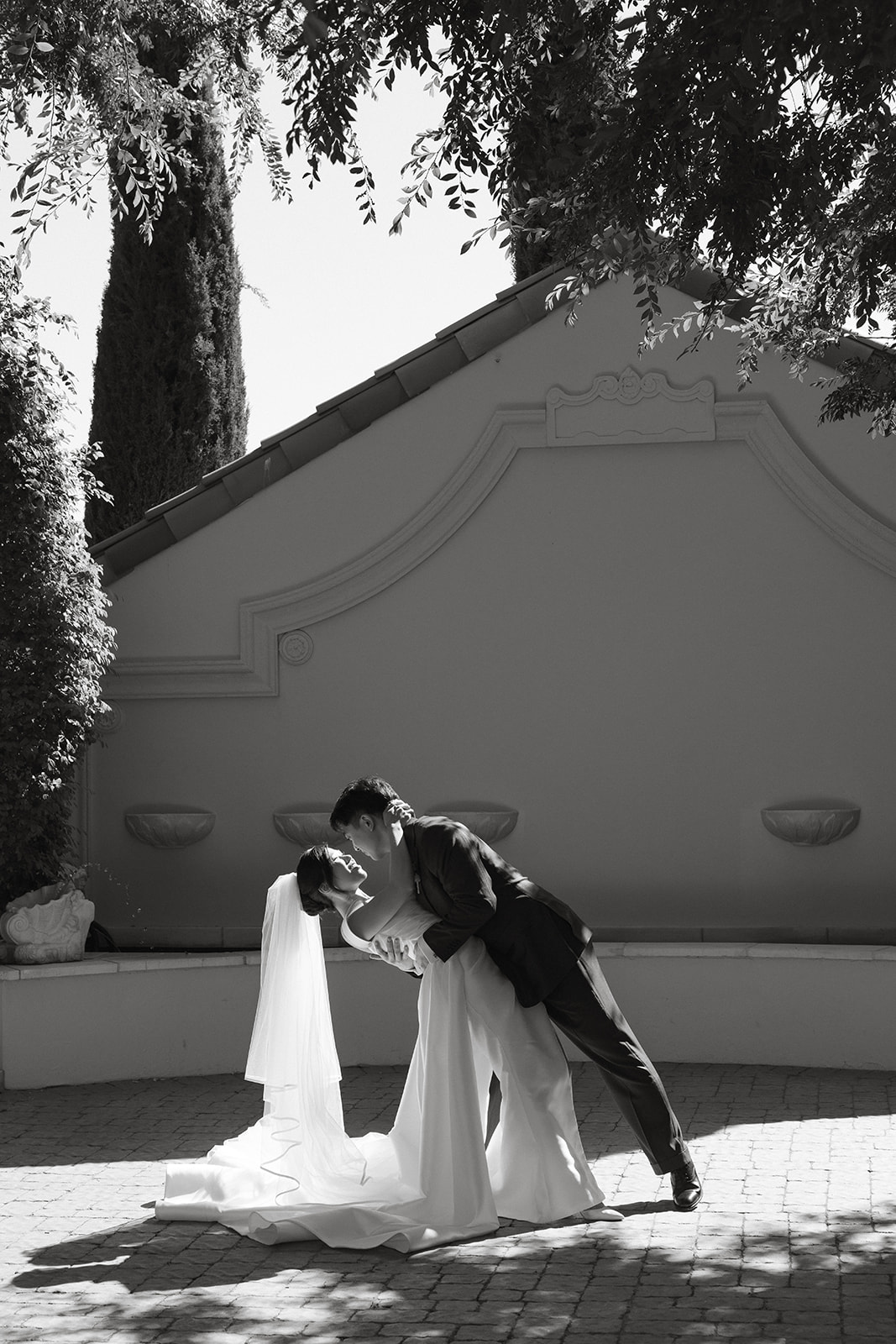 Bride and groom sharing a dramatic dip kiss during portraits at casa real at ruby hill winery, featured in romantic casa real at ruby hill winery photos.