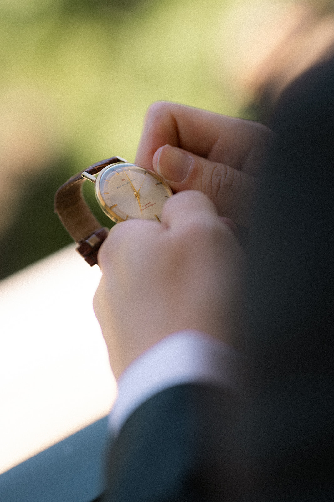 Groom adjusting a vintage wristwatch while getting ready for his wedding at casa real at ruby hill winery, photographed by a bay area wedding photographer.