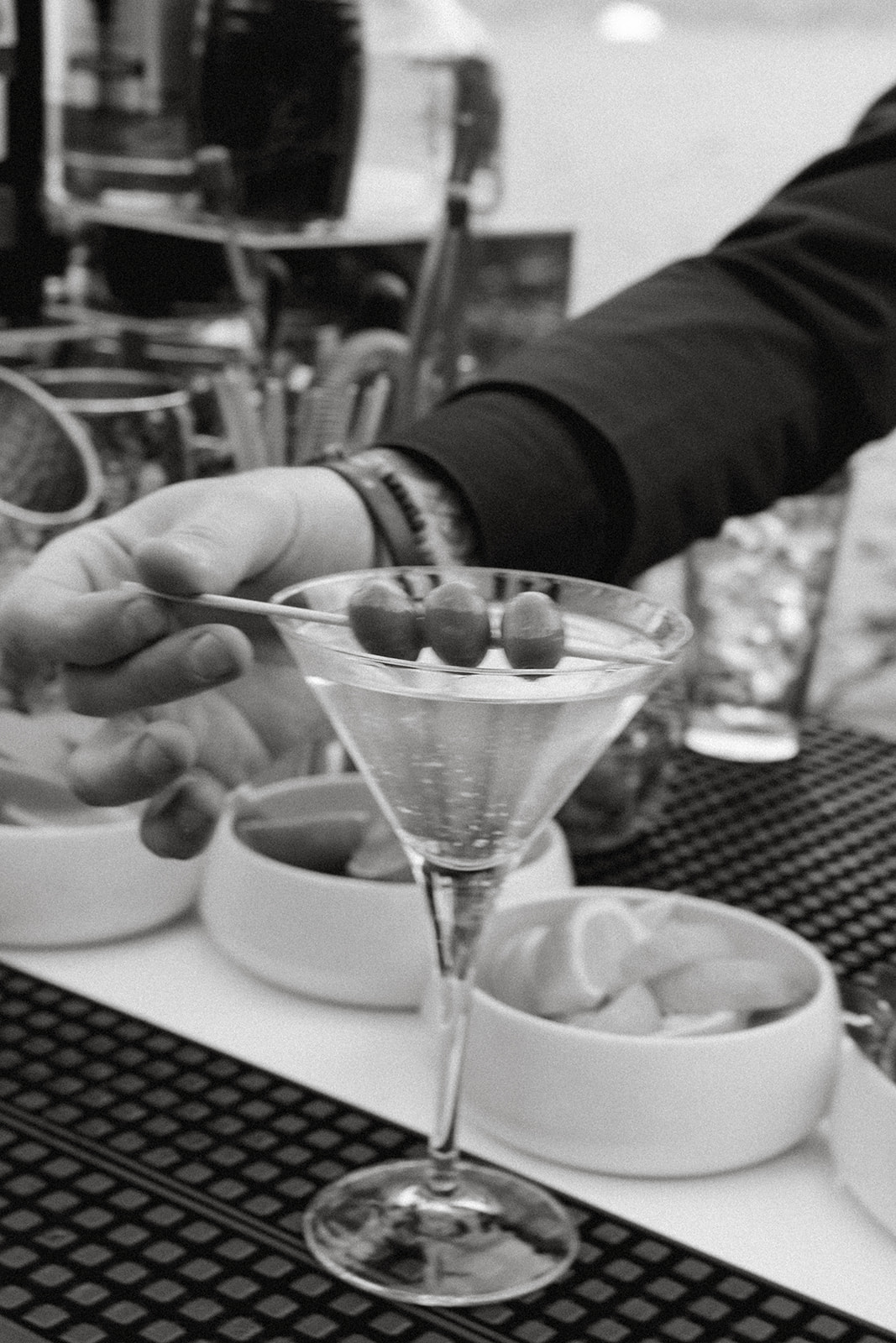 Martini with olive garnish being prepared at the cocktail bar during an Italian destination wedding reception.