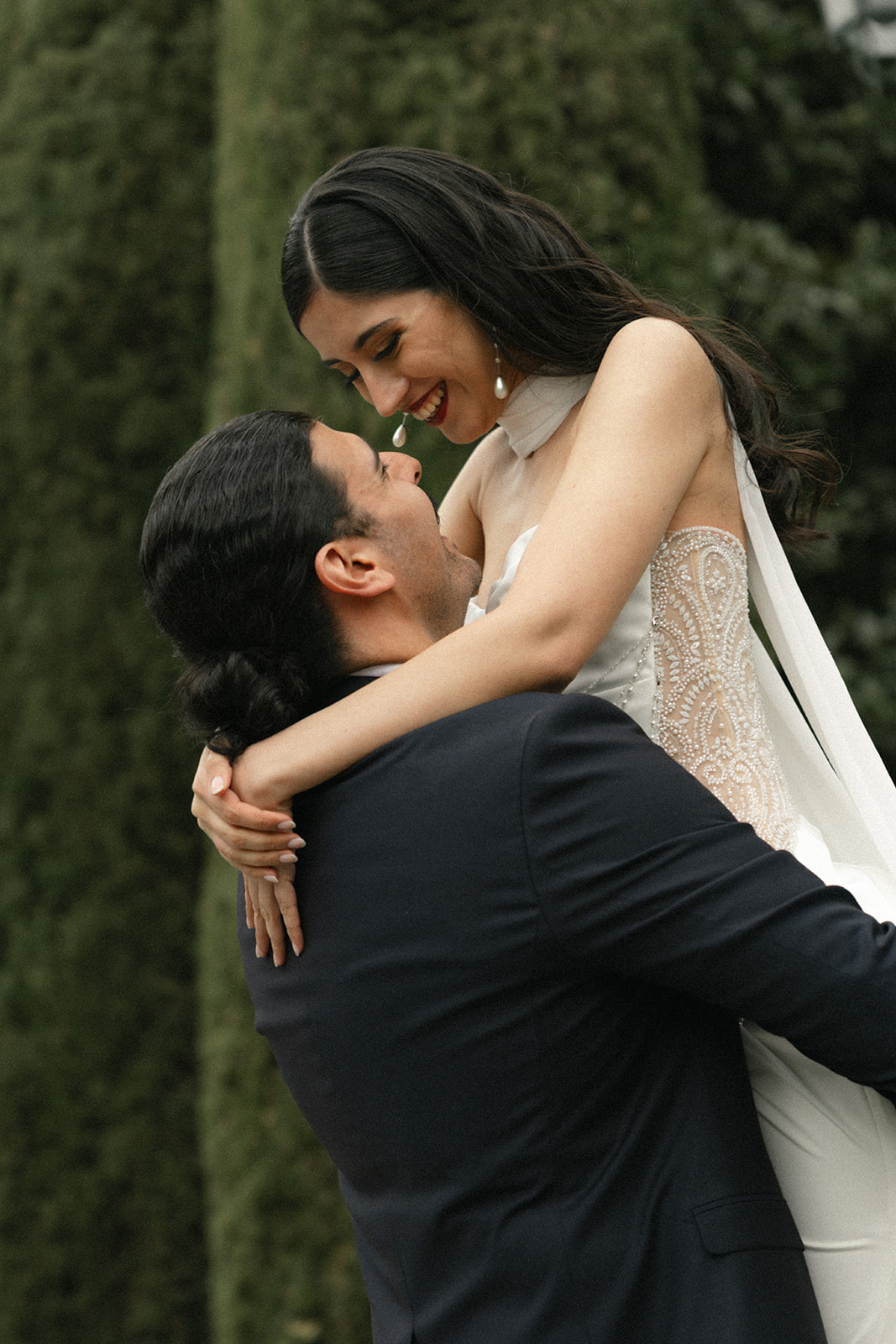 Bride smiling as the groom lifts her in an intimate portrait during an Italian destination wedding.