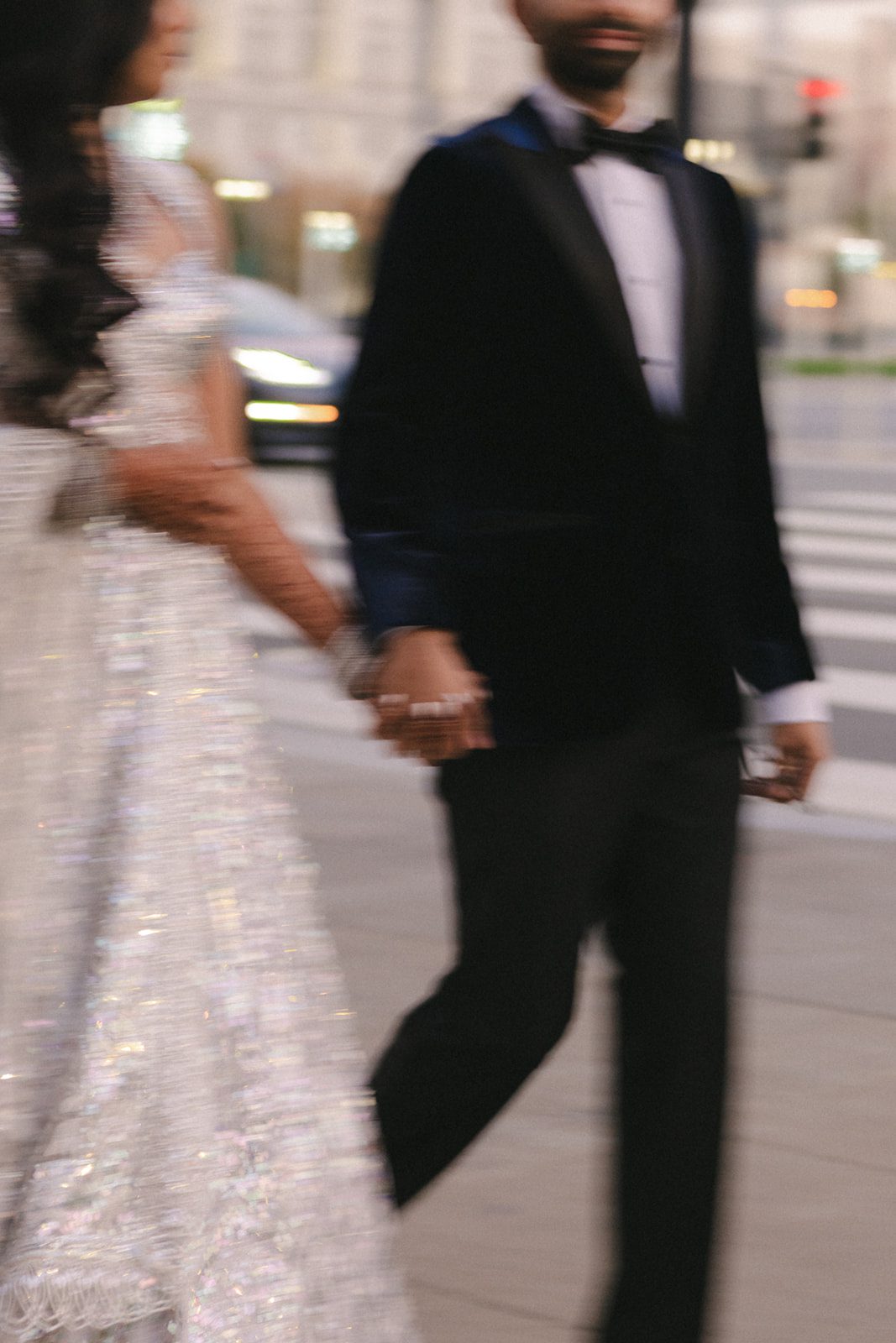 Close-up motion-blurred portrait of a couple holding hands outdoors during their San Francisco City Hall wedding.