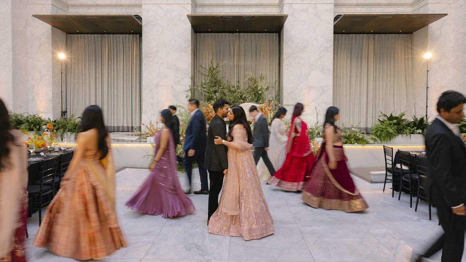 Newlyweds share a kiss on the dance floor as guests move around them during their wedding at The Conservatory at One Sansome.