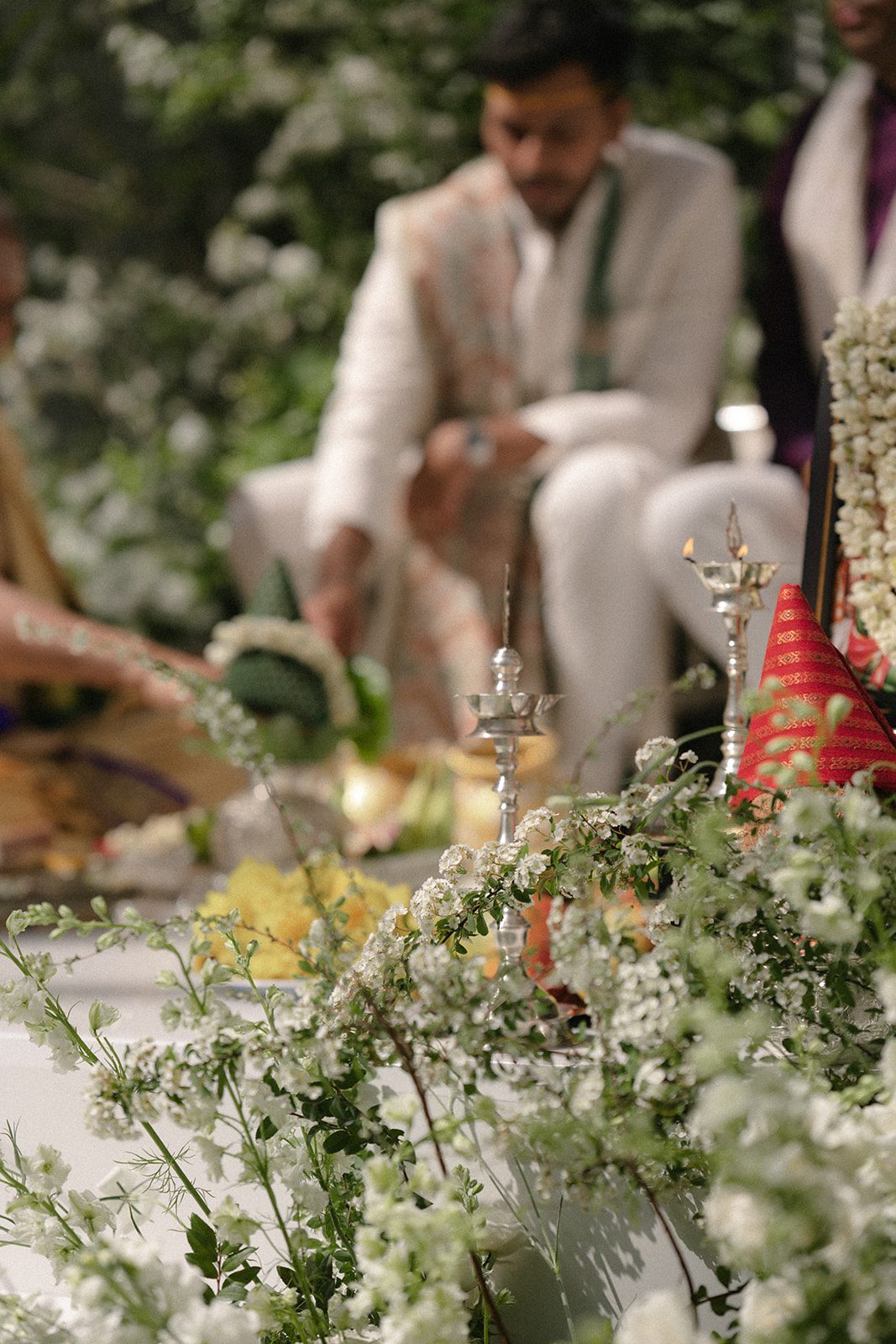 Traditional Telugu wedding ceremony details surrounded by white florals, greenery, and oil lamps during The Conservatory at One Sansome wedding.