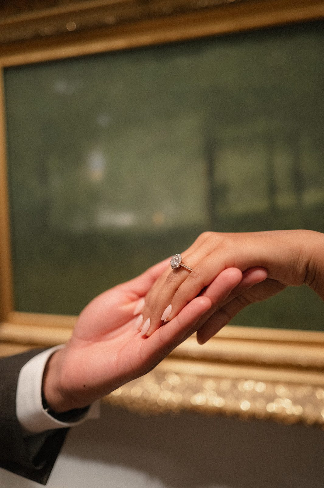 Close-up of an engagement ring resting in a partner’s hand during a museum San Francisco engagement session, highlighting a timeless engagement photography detail.
