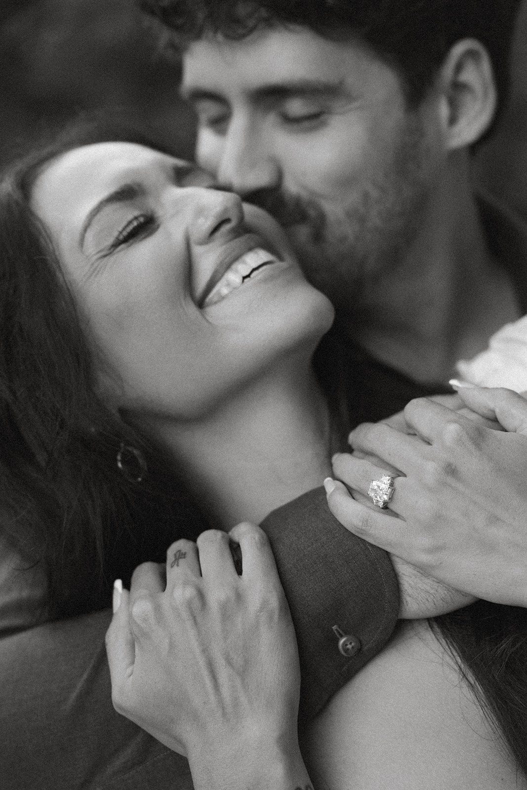 Black-and-white close-up of an engaged couple embracing, with the engagement ring in focus during Northern California engagement photos.