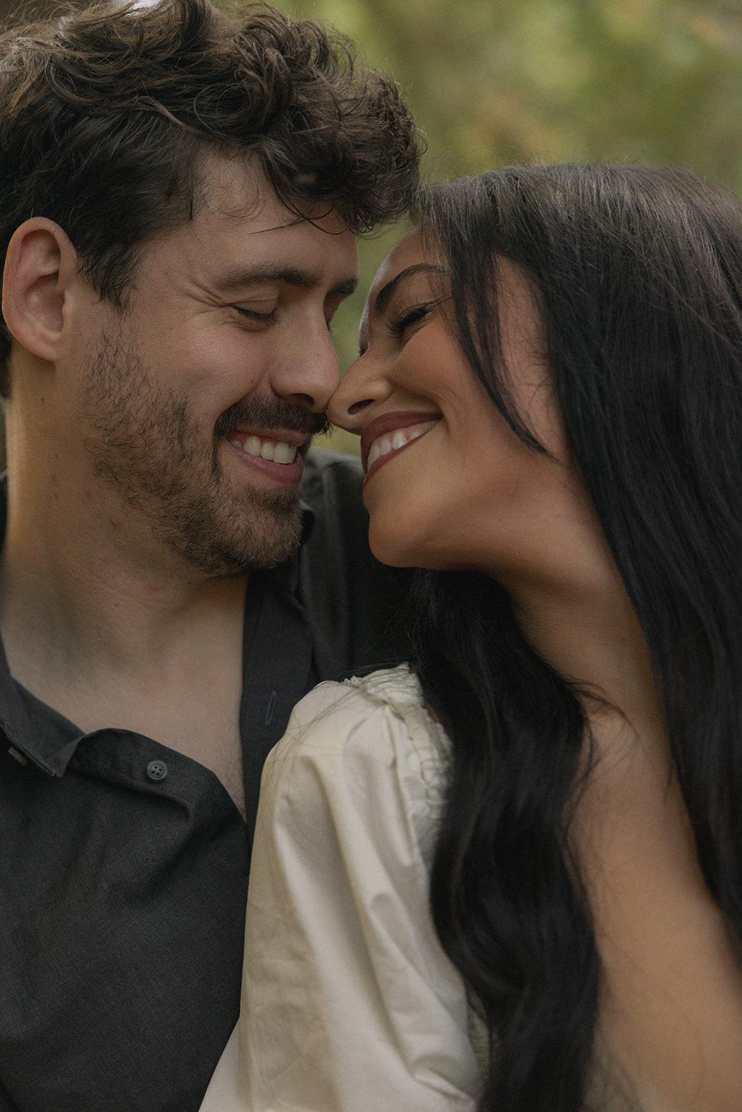 Close-up of an engaged couple smiling face-to-face during Reinhardt Redwood Regional Park Engagement Photos.