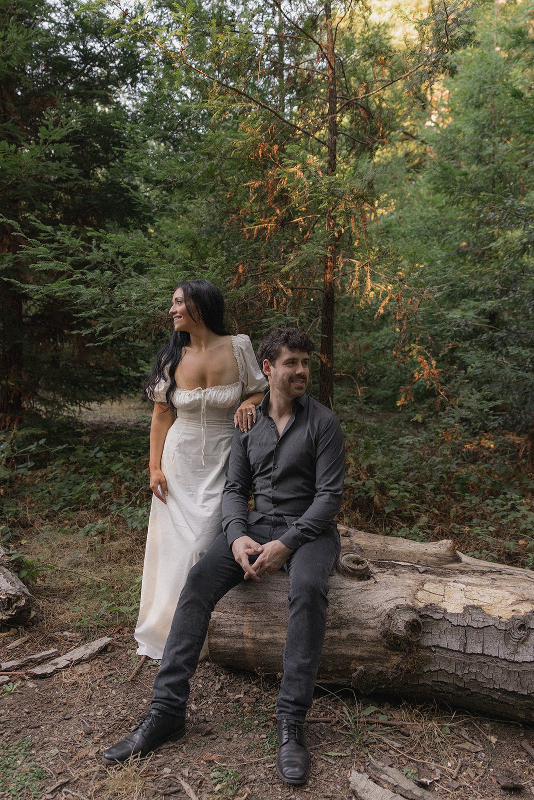 Couple posing beside a fallen tree in the redwoods during Reinhardt Redwood Regional Park Engagement Photos.