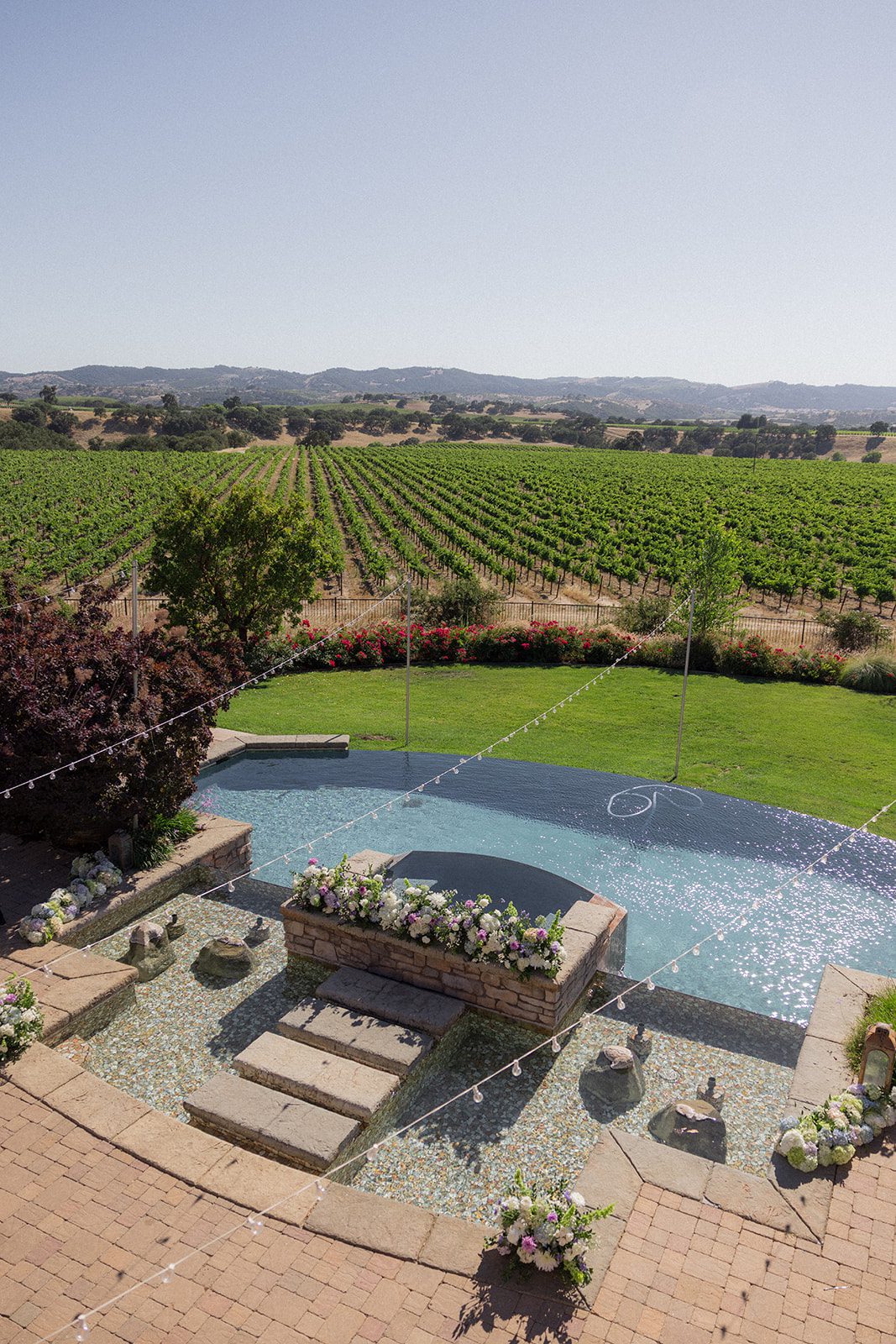 Overhead view of the fountain, floral arrangements, and sprawling grapevines at Villa San Juliette, a California vineyard wedding venue.